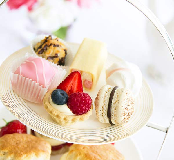 A two-tiered cake stand with sweet treats