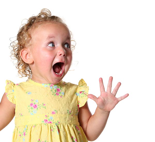 Little girl with surprised face in yellow dress