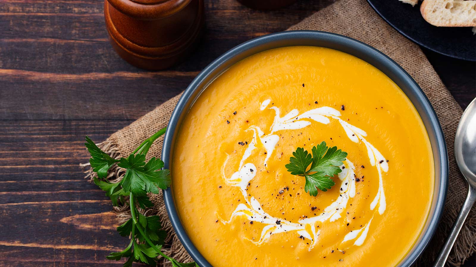 Pumpkin soup plated upon a wooden bowl